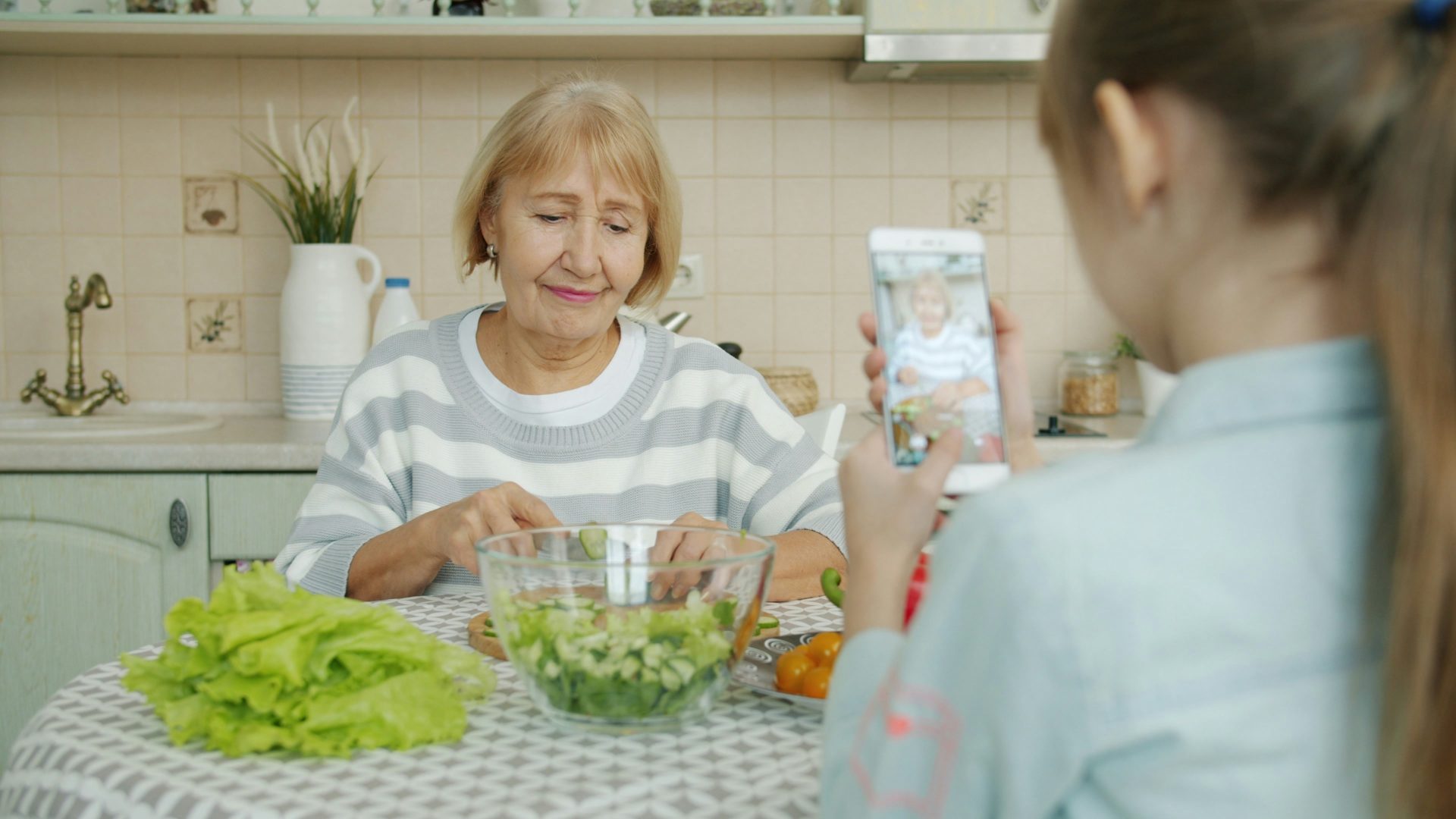 Grandmother and granddaughter making salad in kitchen